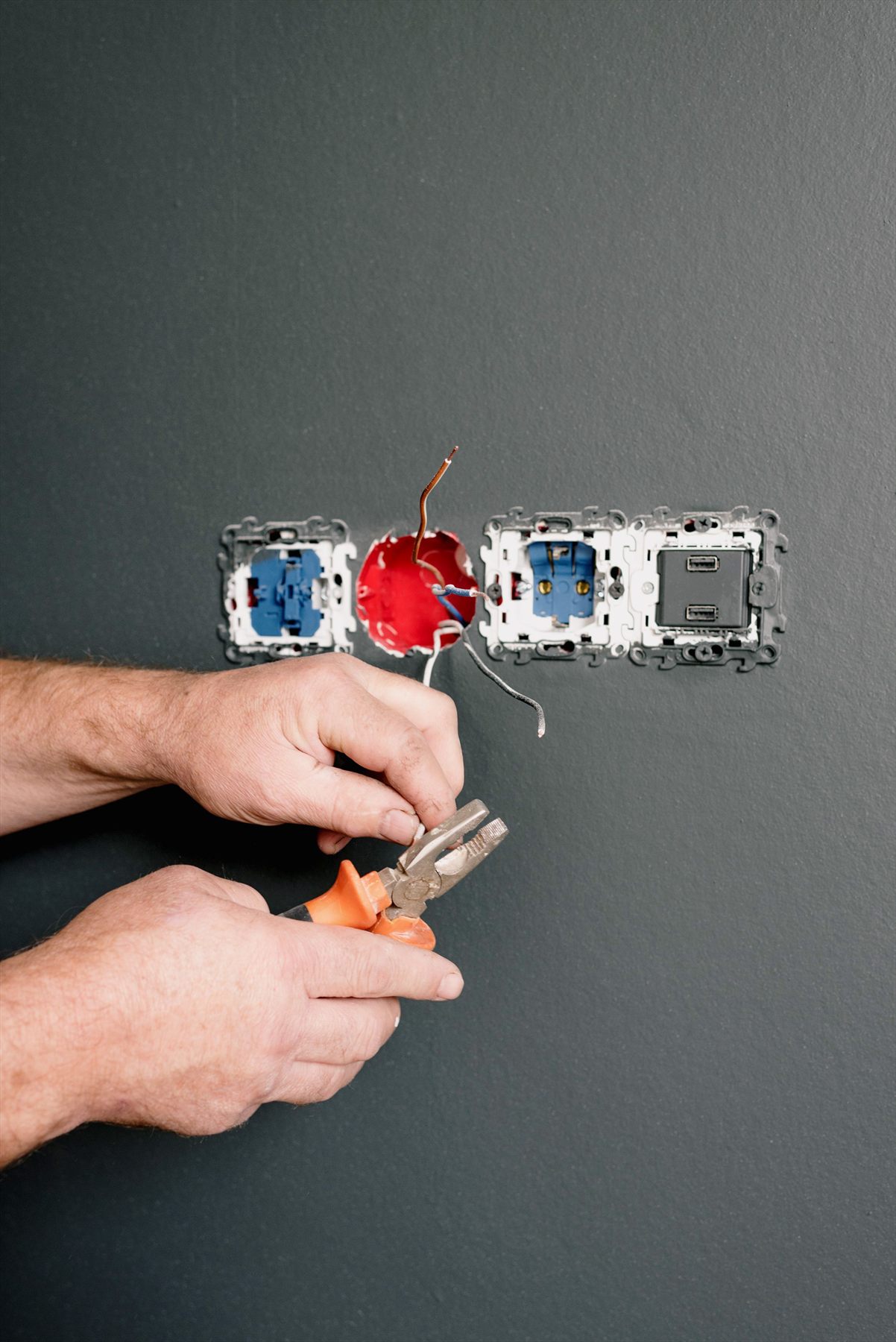 Electrician wiring a wall socket during an electrical appliance installation